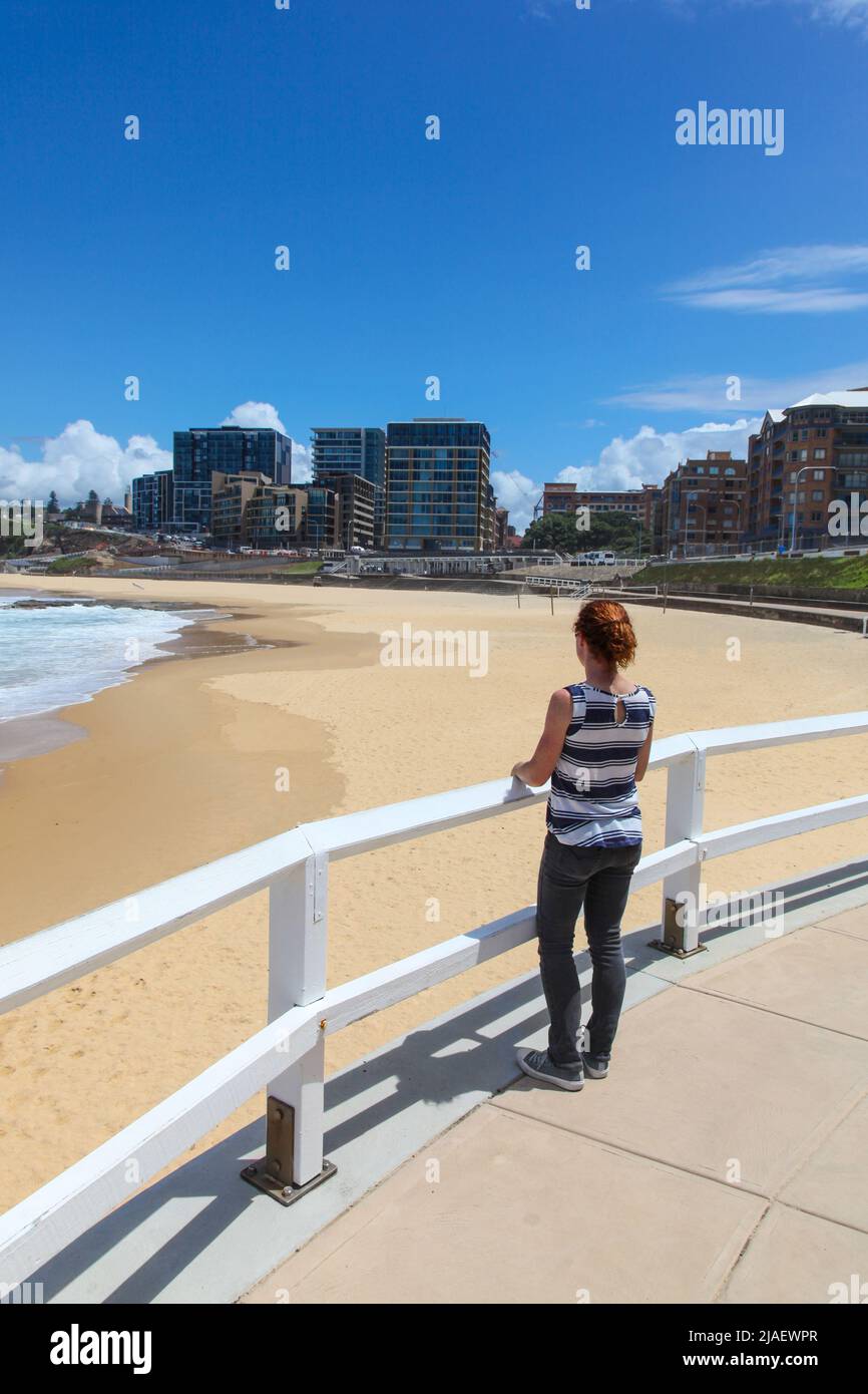 A woman enjoys the view at Newcastle Beach. This beach a few minutes from the CBD is one of the highlights of the Newcastle, New South Wales second la Stock Photo