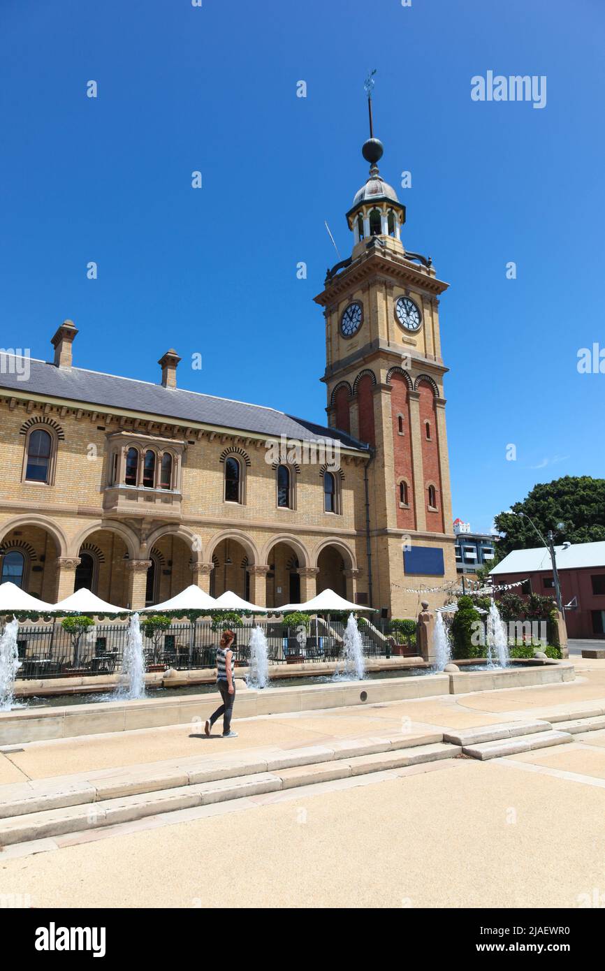 Woman walking past Customs House - Newcastle. Newcastle is Australia's second oldest  city a couple of hours north of Sydney and home to some great hi Stock Photo