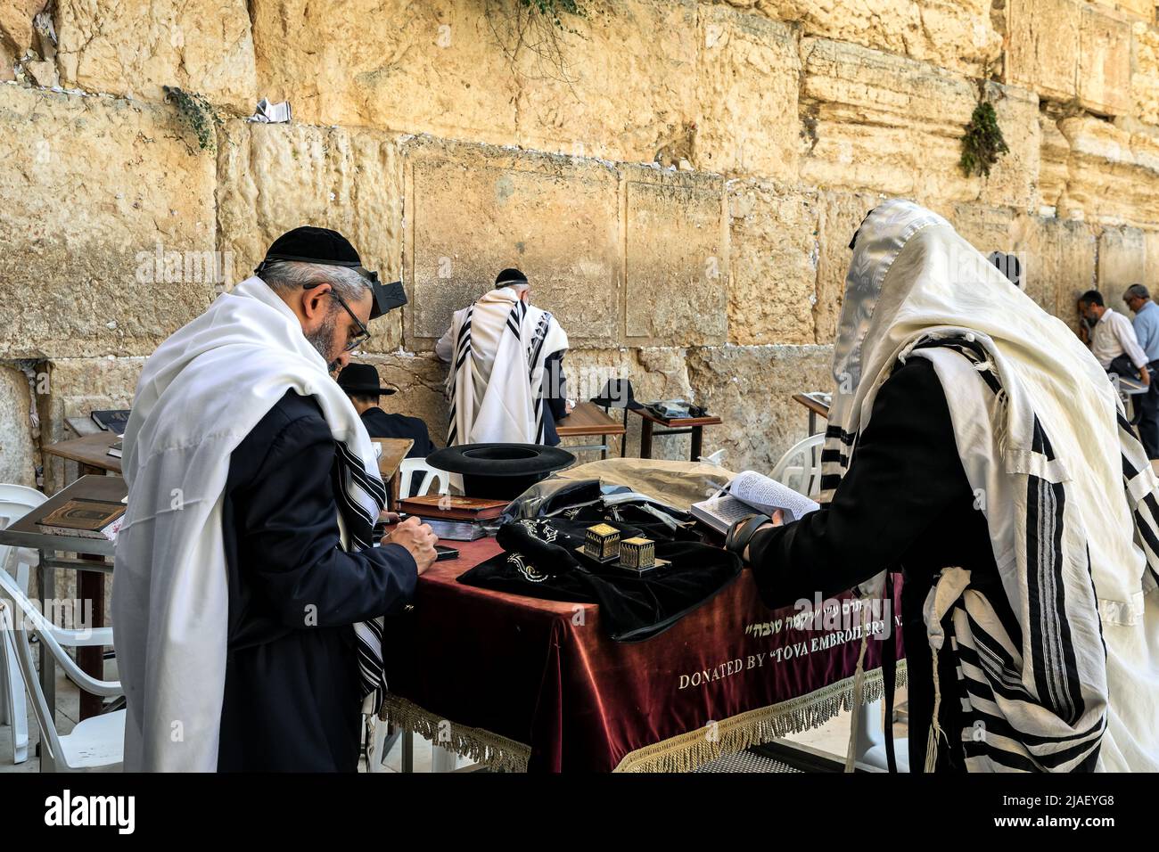 Religious men with tefillin  and covered with tallit praying at the Wailing Wall in Jerusalem, Israel. Stock Photo