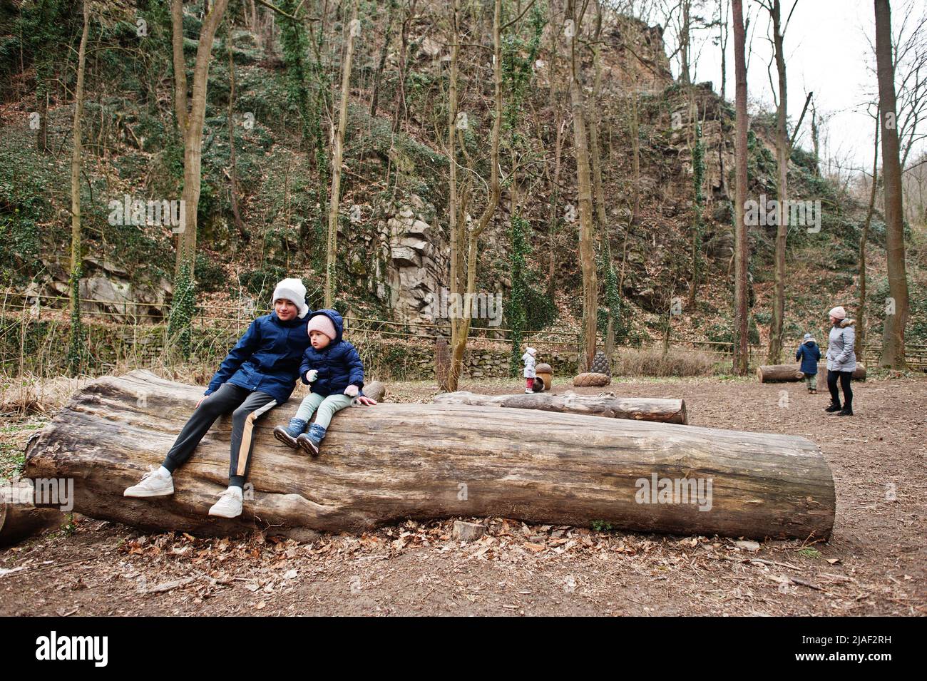 Brother with sister sitting on wood at Znojmo park in Czech Republic Stock Photo
