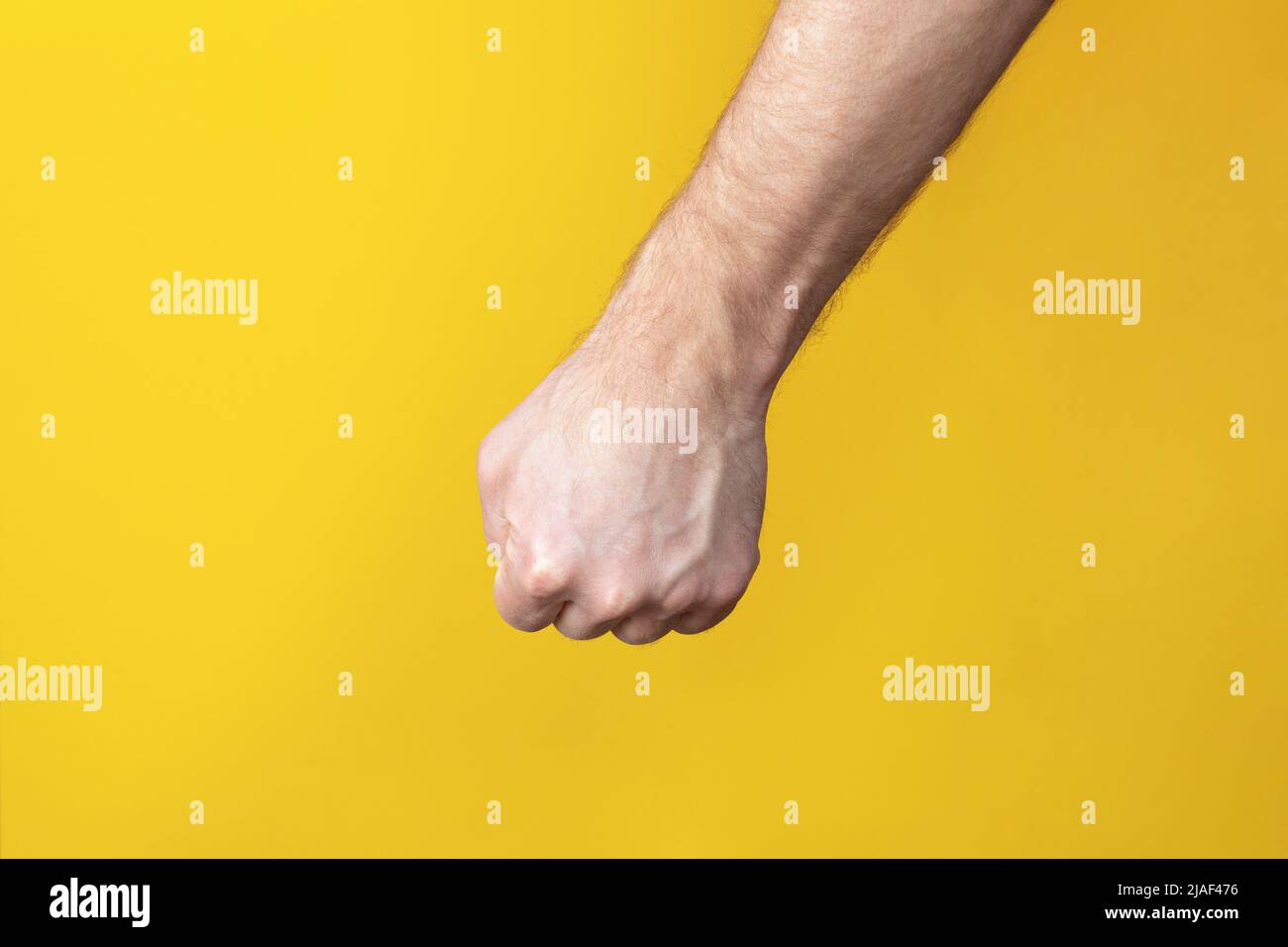 Hand Using Force Hand of caucasian man on yellow background doing protest and revolution ...