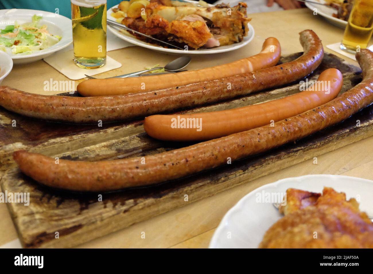 Close up German sausages and deep fried pork knuckle legs served with