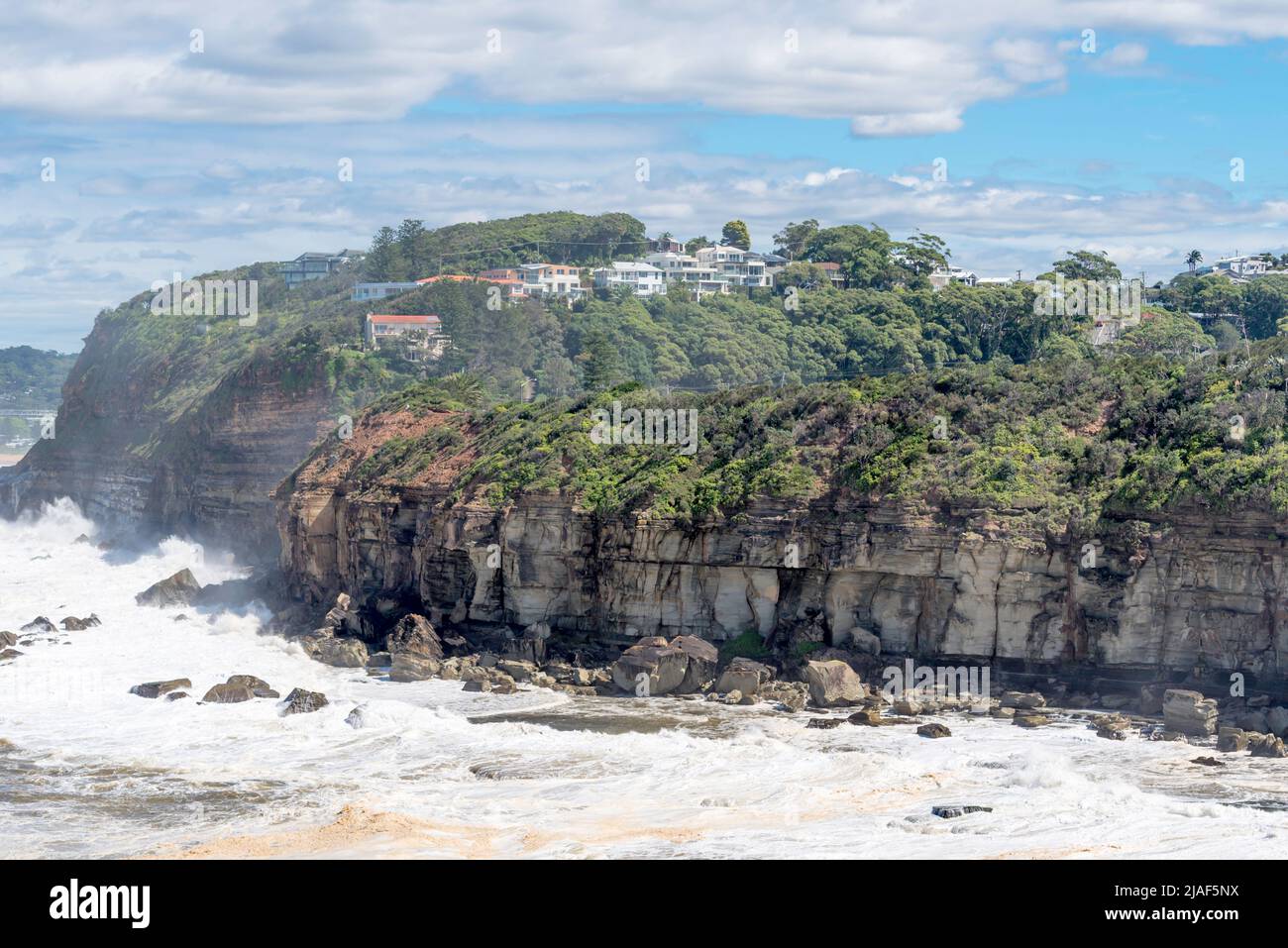 April 4th 2020, Terrigal, NSW, Australia: Seaspray blows up over the headland between Terrigal and North Avoca as wild seas batter the coastline Stock Photo