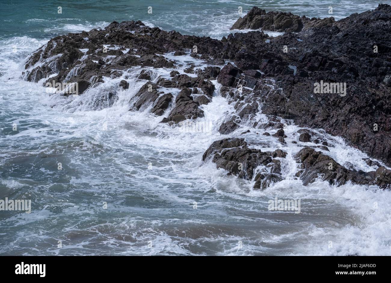 Crashing waves over the rocks at Kynance, Cornwall, England. Stock Photo