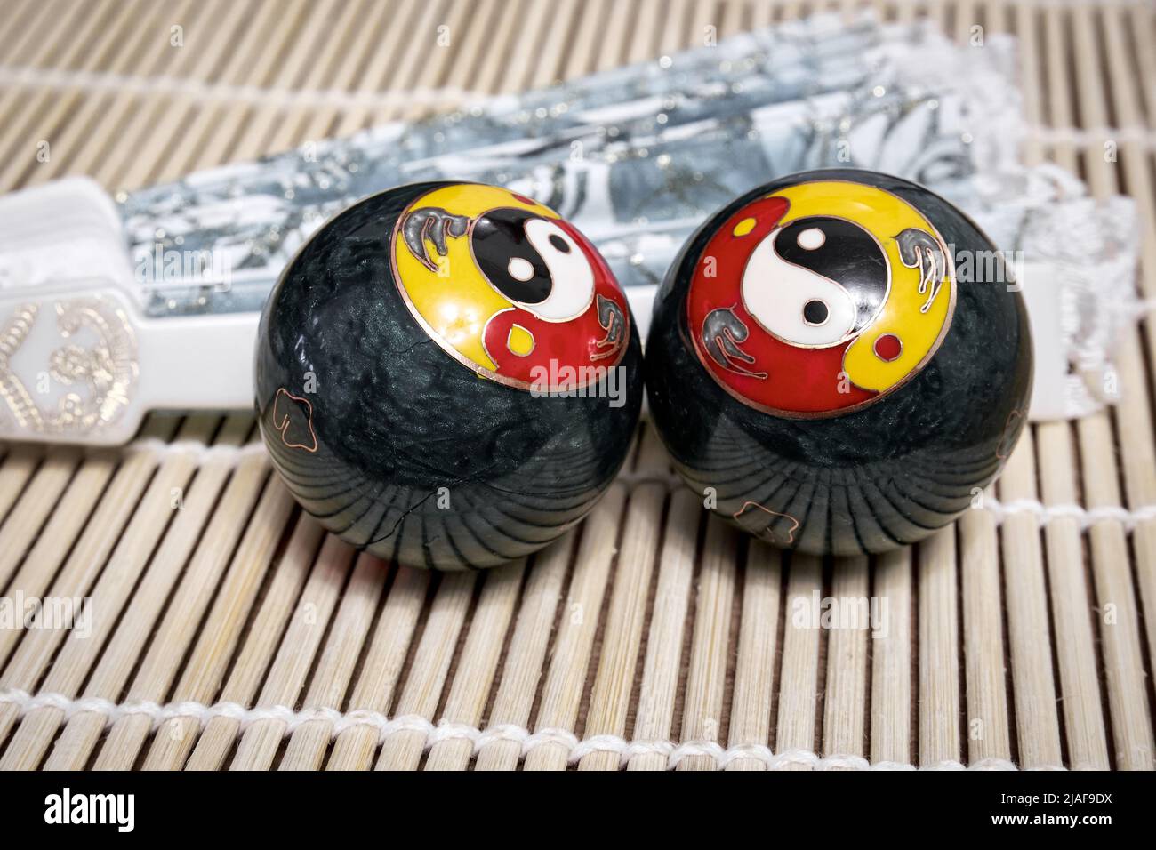 Chinese meditation balls and a fan. Baoding balls with yinyang symbol Stock Photo Alamy
