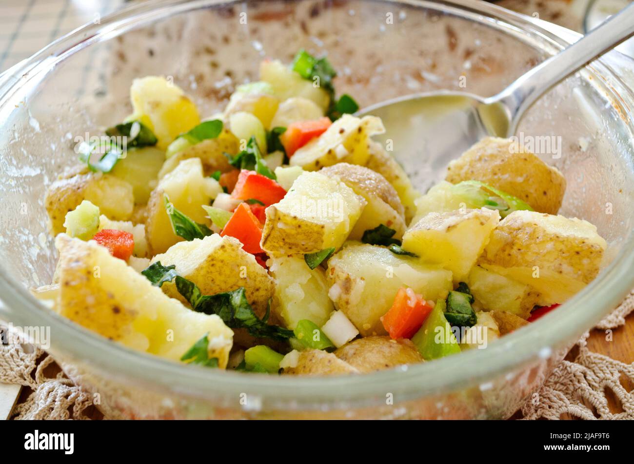 Homemade potato salad with fresh basil and red bell peppers. Vegan potato salad with a vinaigrette. Stock Photo