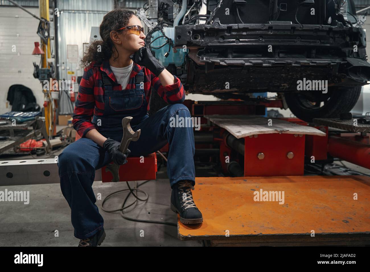 Female auto mechanic sitting in car repair station Stock Photo Alamy