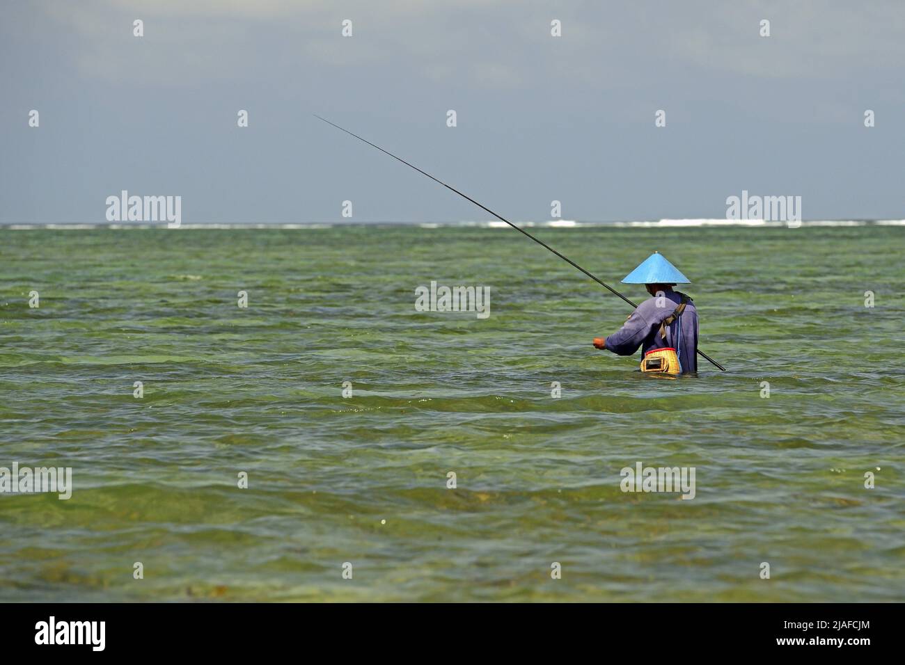 Angler in the sea at the beach of Sanur, Indonesia, Bali Stock Photo