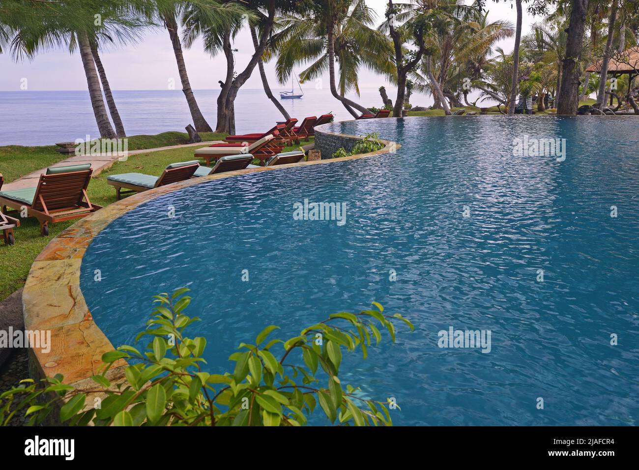 Swimming pool of a luxury hotel at the Lovina Beach with view onto the Indian Ocean, Indonesia, Bali Stock Photo