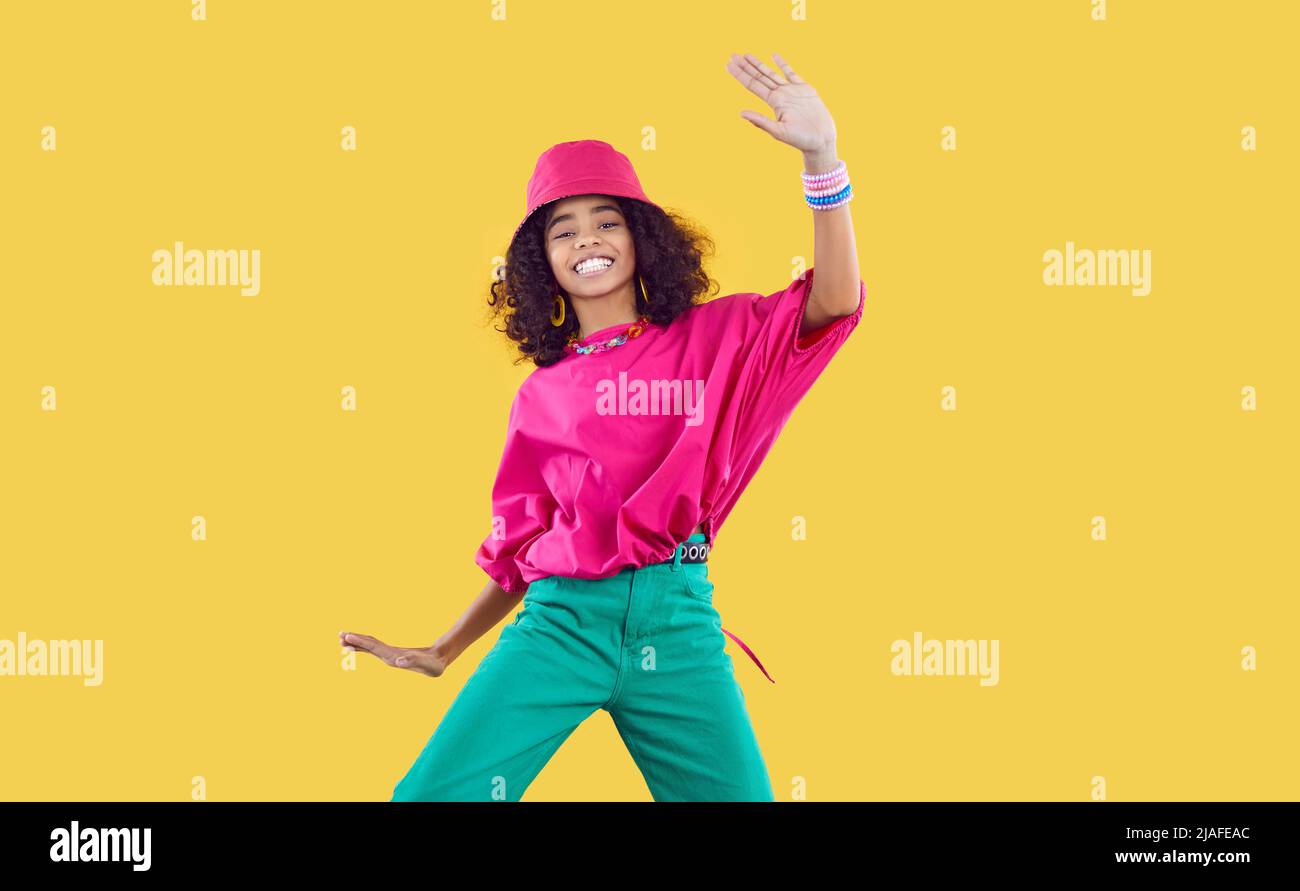 Happy African dancer girl in funky outfit dancing and having fun in fashion studio Stock Photo