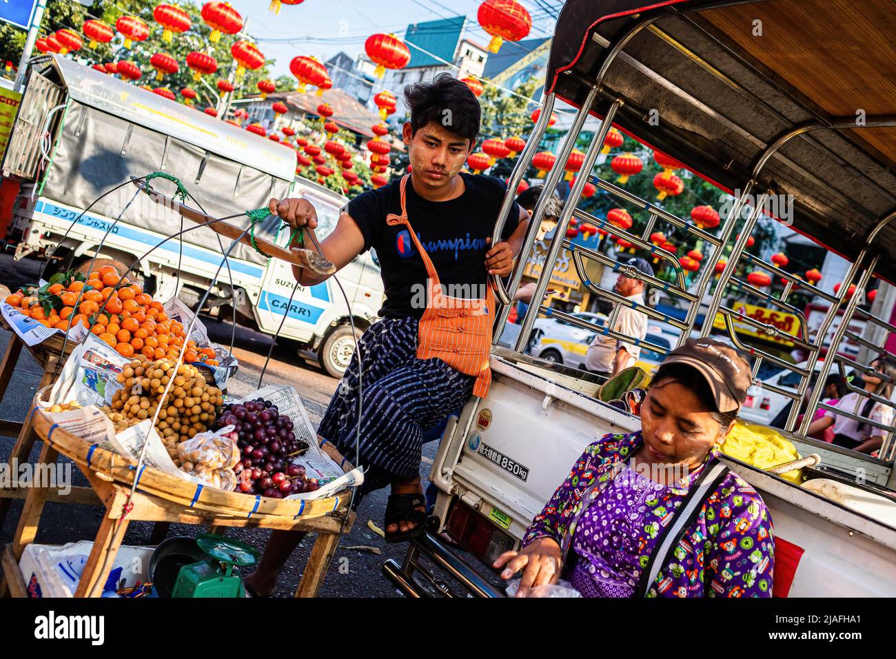 Yangon, Myanmar. 16th Jan, 2020. A street seller holds on a fruit basket on the streets of