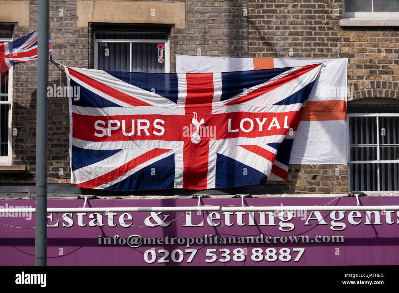 Spurs loyal Union Jack flag hanging from a flat above shops on 18th May 2022 in East London, United Kingdom. Tottenham Hotspur Football Club, commonly referred to as Spurs, is an English professional football club based in Tottenham, that competes in the Premier League. Stock Photo