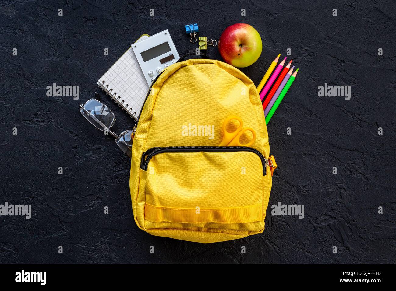 Yellow school backpack with student accessories. College and school concept Stock Photo