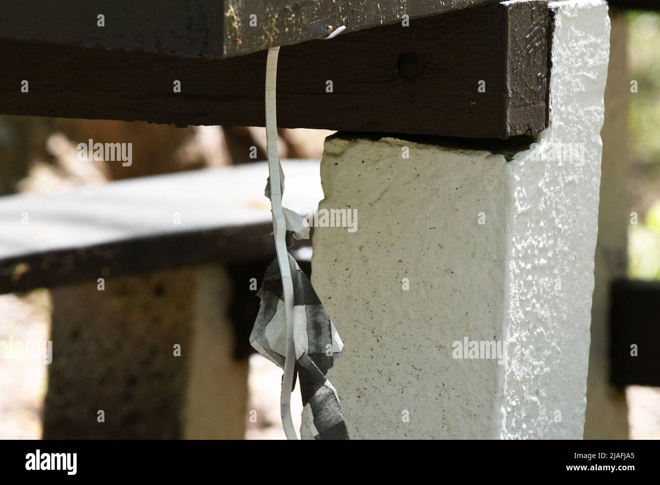 HANGMAN: A character created out of paper dangles by the neck from a picnic table simulating the hanging of a man in Menlo park of Edison, New Jersey. Stock Photo