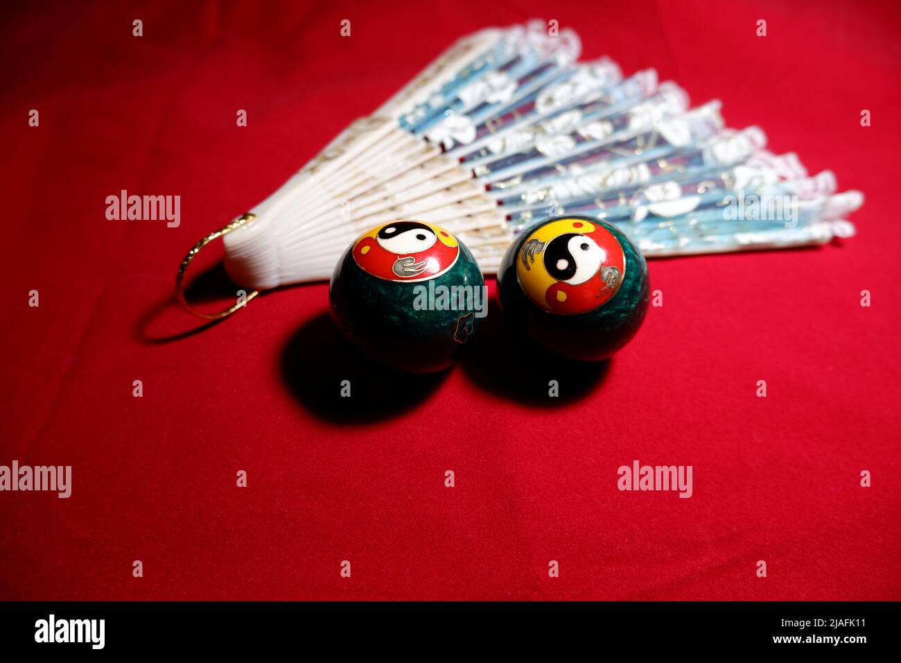 Chinese meditation balls and a fan. Baoding balls with yinyang symbol