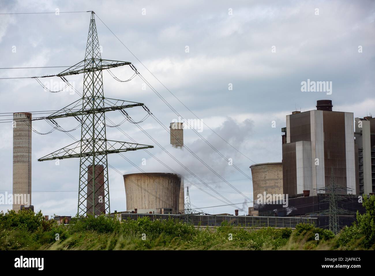 RWE Weisweiler Lignite-fired Power Plant In NRW. Steaming Cooling Tower With A High Voltage Pylon Next To It Stock Photo