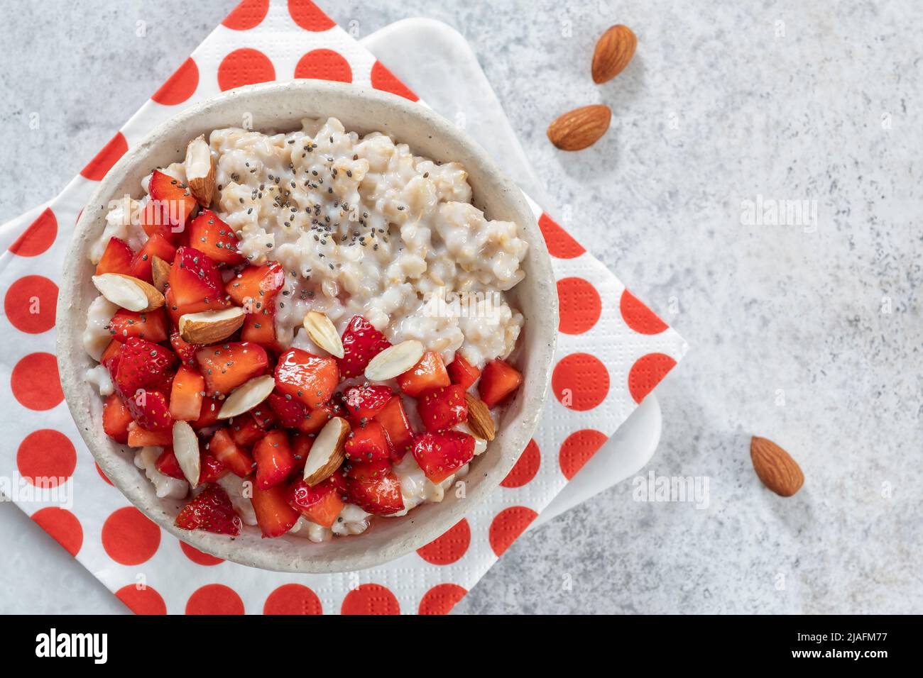 Oatmeal porridge with strawberries top view. Porridge oats in bowl. Healthy food breakfast Stock Photo