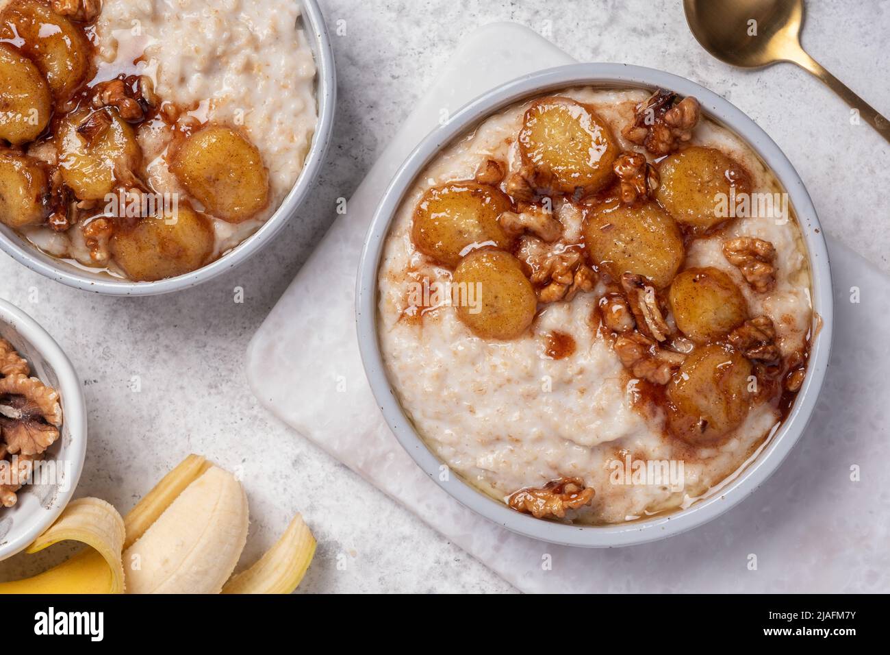 Porridge with caramelised banana and walnut for healthy breakfast Stock Photo
