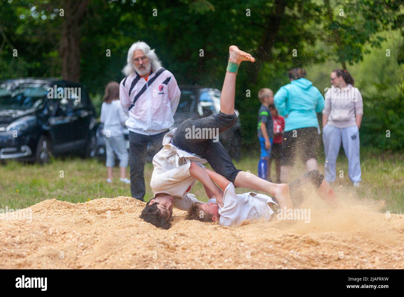 Pleyber-Christ, France - May 29 2022: Two youngsters practicing Breton wrestling (gouren) taking place on sawdust. Stock Photo