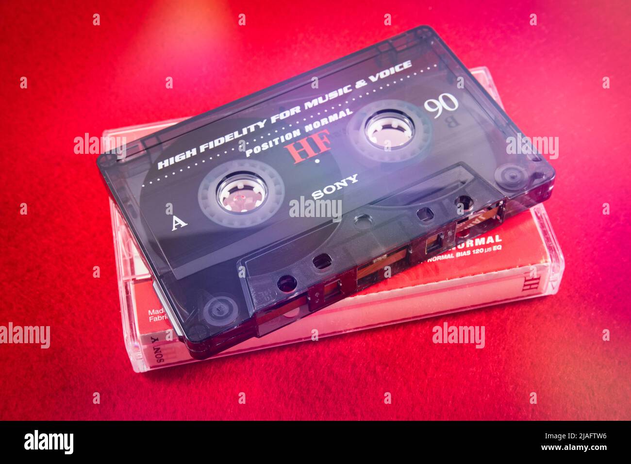 Audio cassette on a red background. Analog audio tape recording Stock