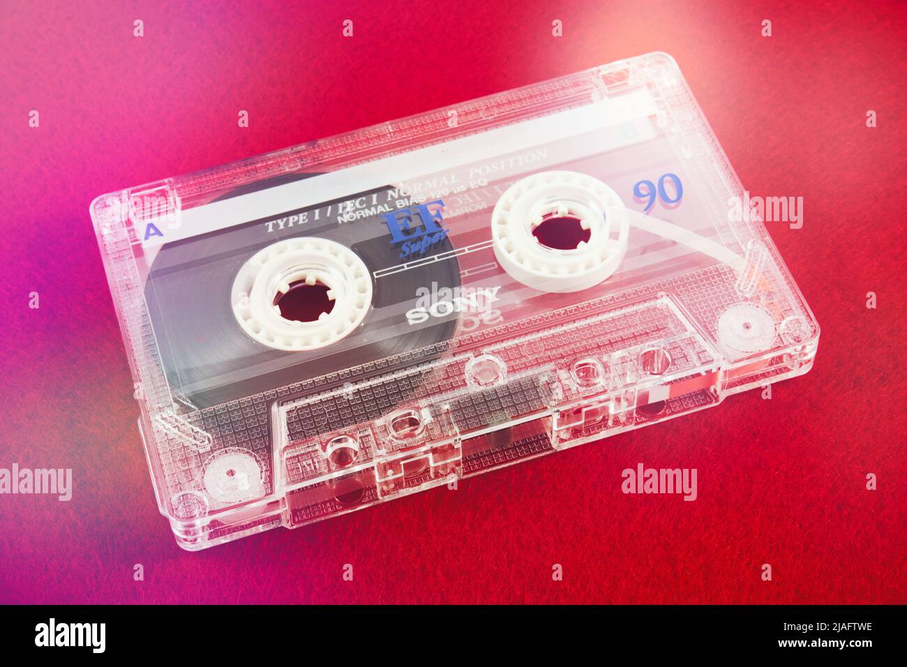 Audio cassette on a red background. Analog audio tape recording Stock