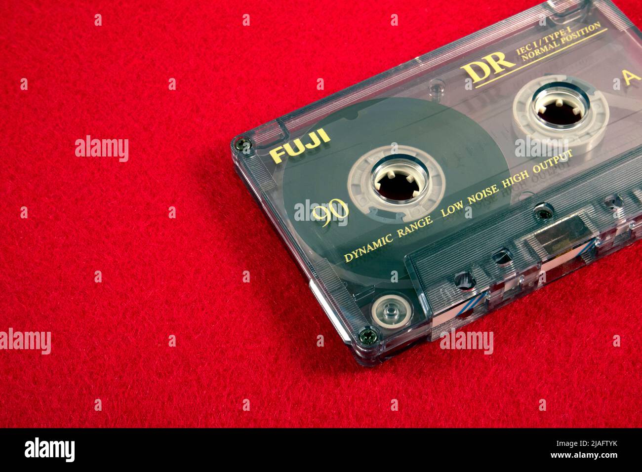 Audio cassette on a red background. Analog audio tape recording Stock