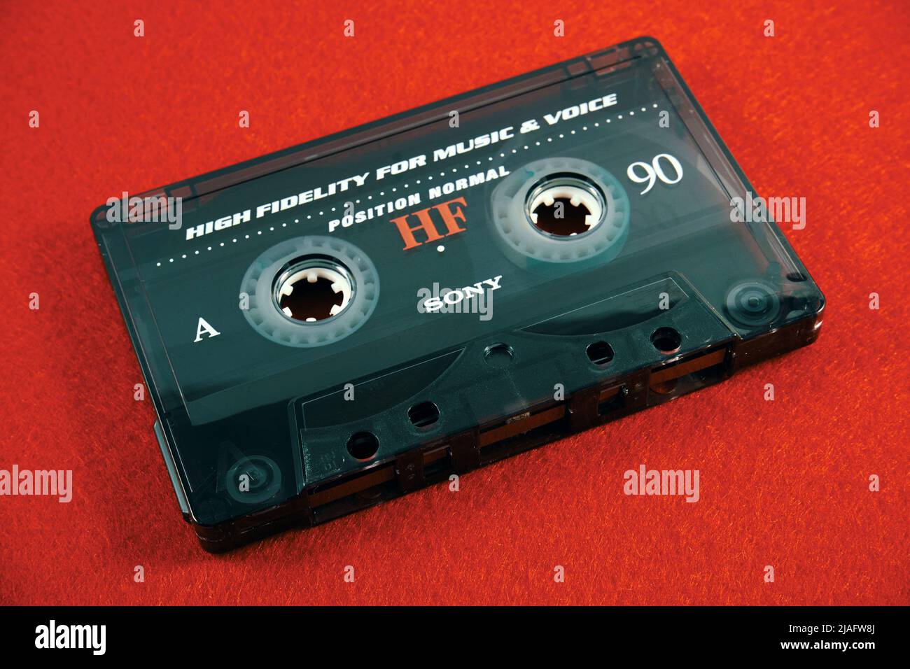 Audio cassette on a red background. Analog audio tape recording Stock