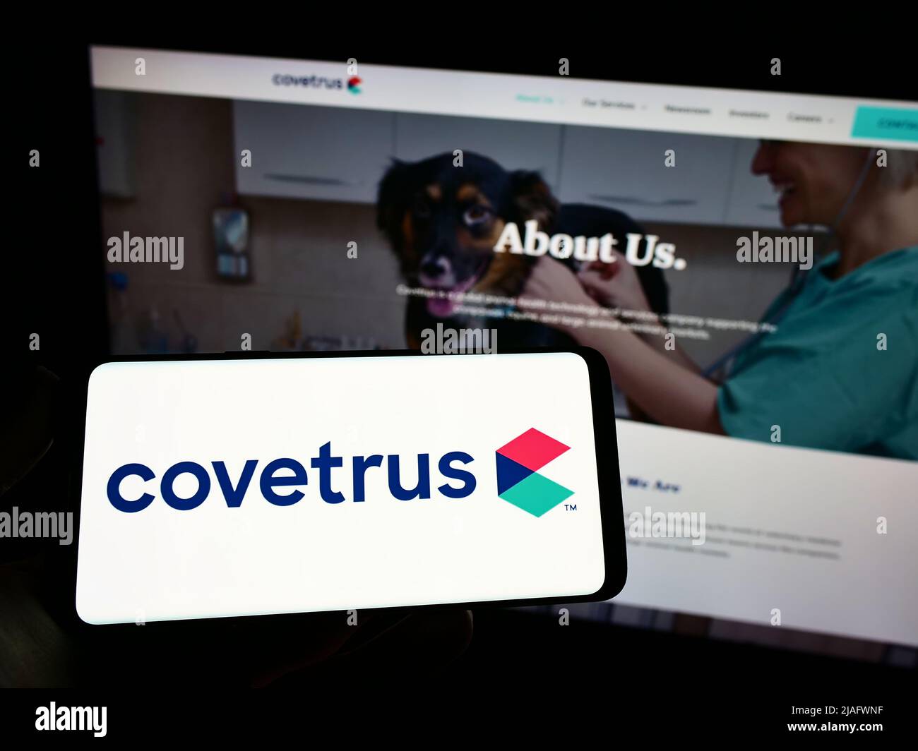 Person holding mobile phone with logo of American animal health company