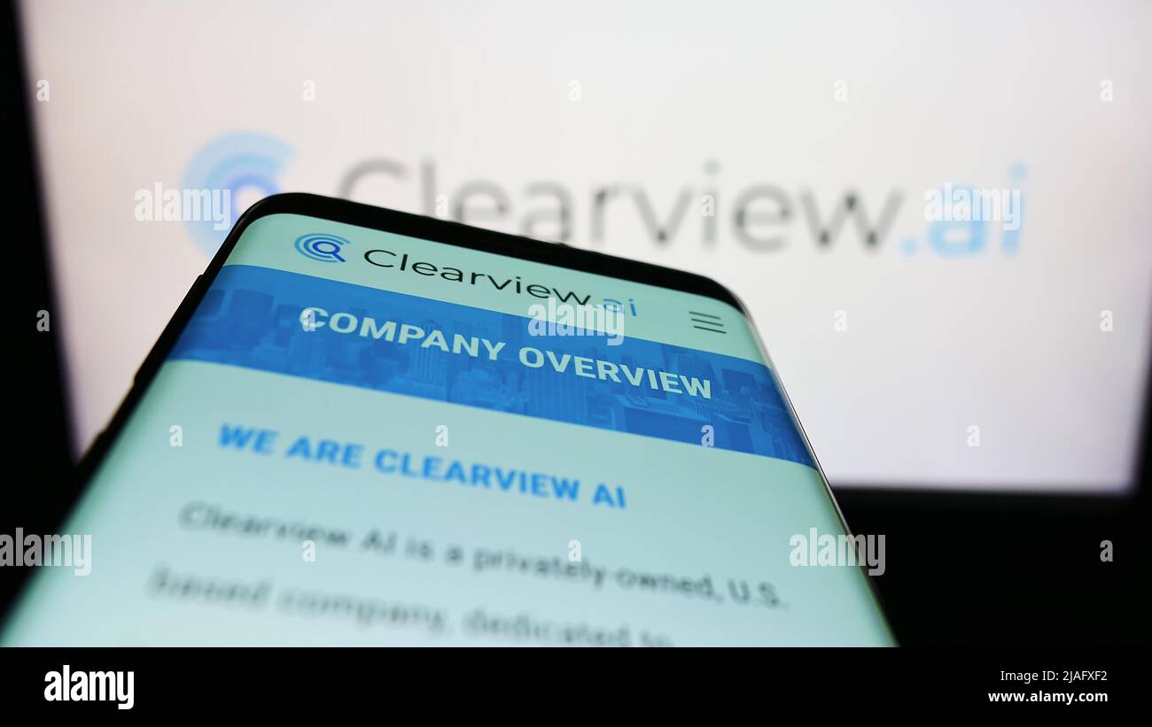 Mobile phone with website of US facial recognition company Clearview AI Inc. on screen in front of logo. Focus on top-left of phone display. Stock Photo