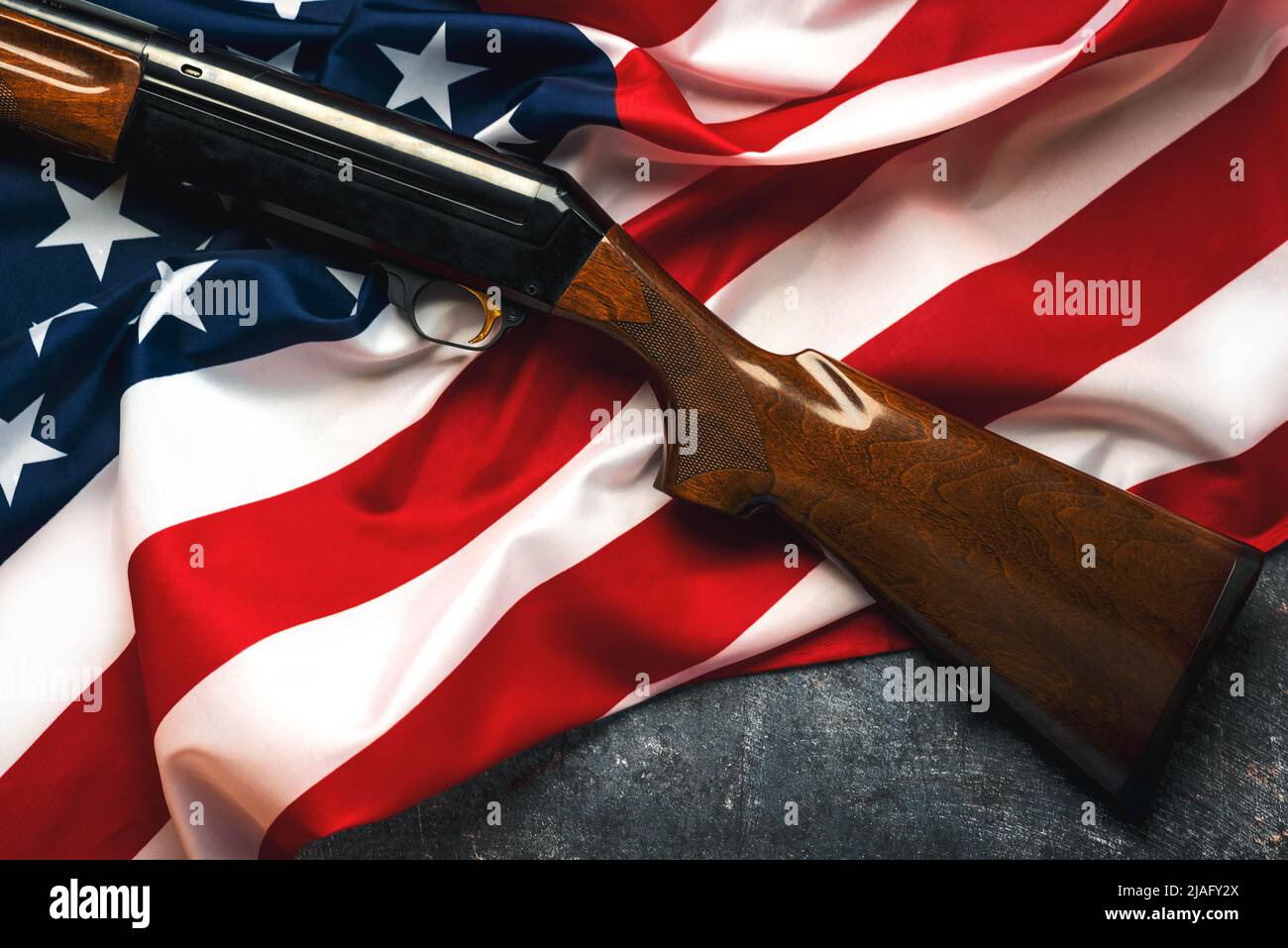 Shotgun over American Flag. Gun control and rights Stock Photo