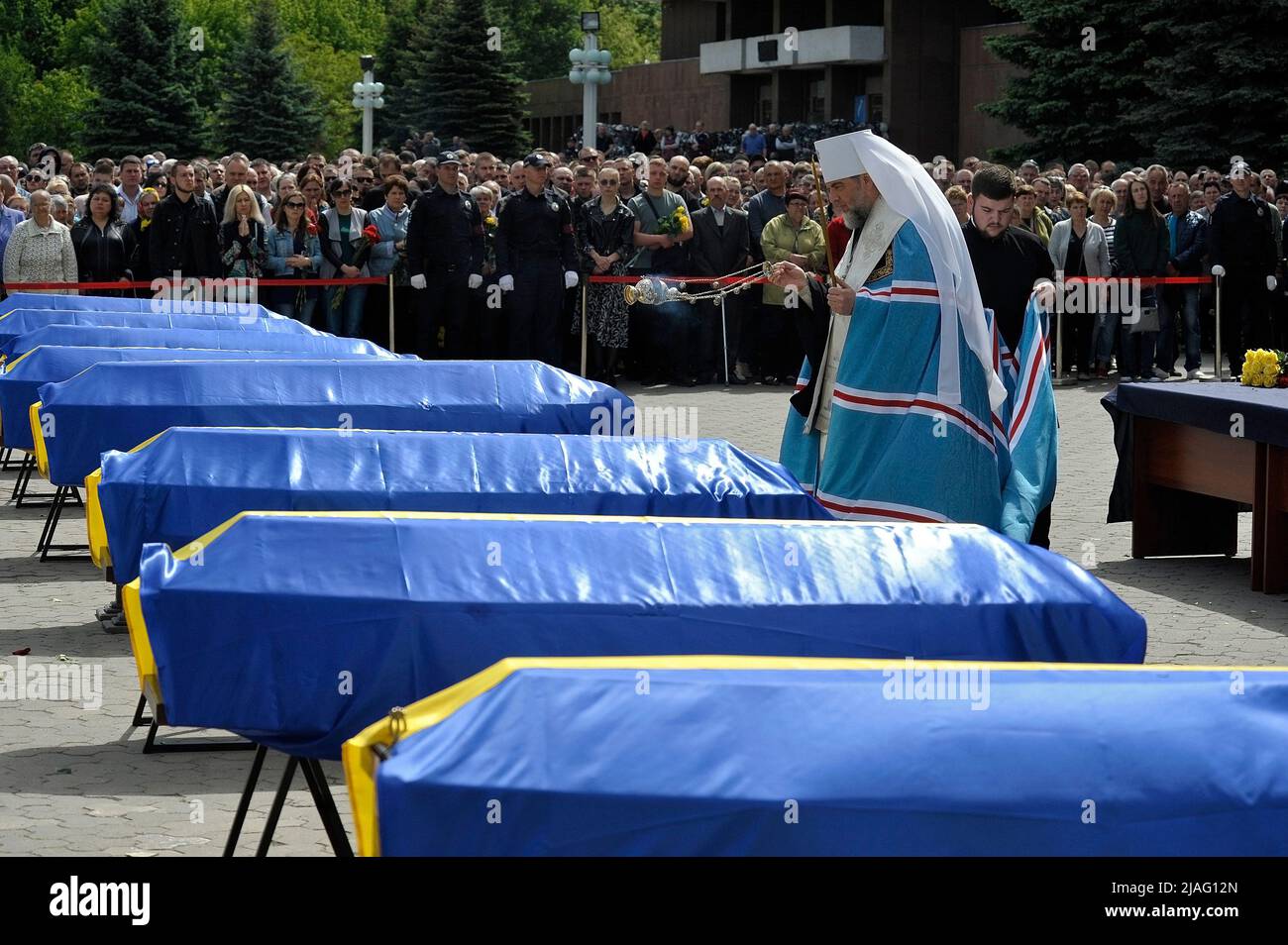 VINNYTSIA, UKRAINE - MAY 29, 2022 - A priest swings a censer at the coffins with the bodies of nine KORD servicemen who perished in a Russian missile Stock Photo