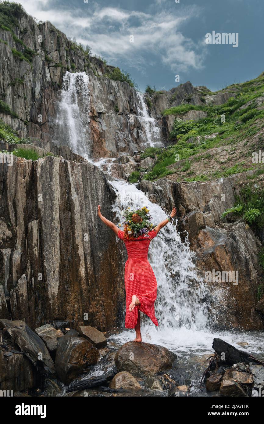 Young beautiful girl in the red dress with on the background of the Adishi glacier. Adish Glacier in Svaneti and the Caucasus Mountains. Stock Photo