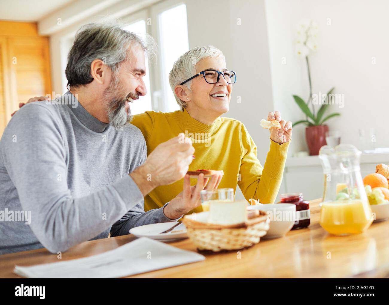 senior couple breakfast home food lifestyle eating table home man woman together husband wife family Stock Photo