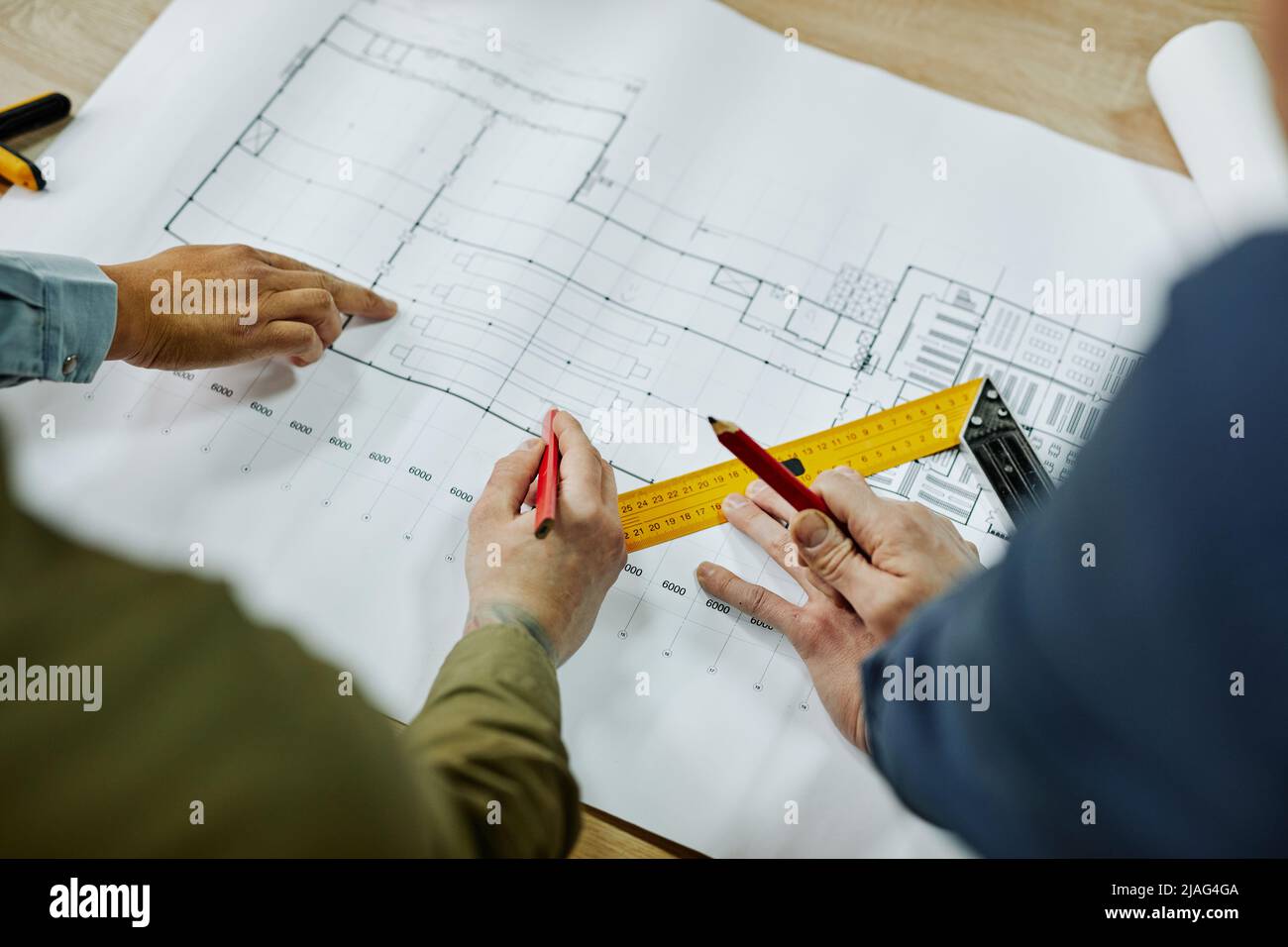 Top view close up of two architects discussing floor and furniture plans, copy space Stock Photo