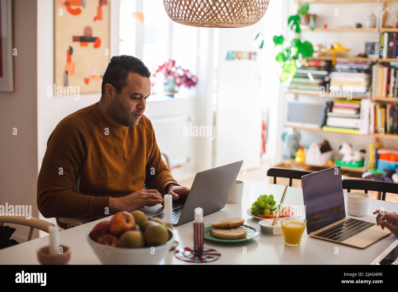 Male freelancer using laptop while working from home Stock Photo