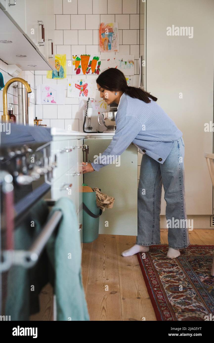 Side view of girl working in kitchen at home Stock Photo