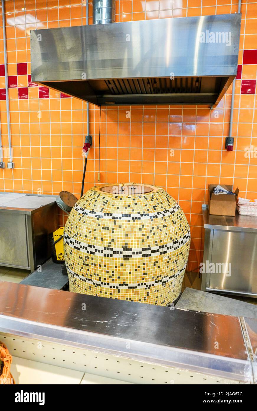 Large tandoor oven for making flat unleavened white bread in the form of a thin flatbread made of wheat flour. The furnace is in the shop Stock Photo