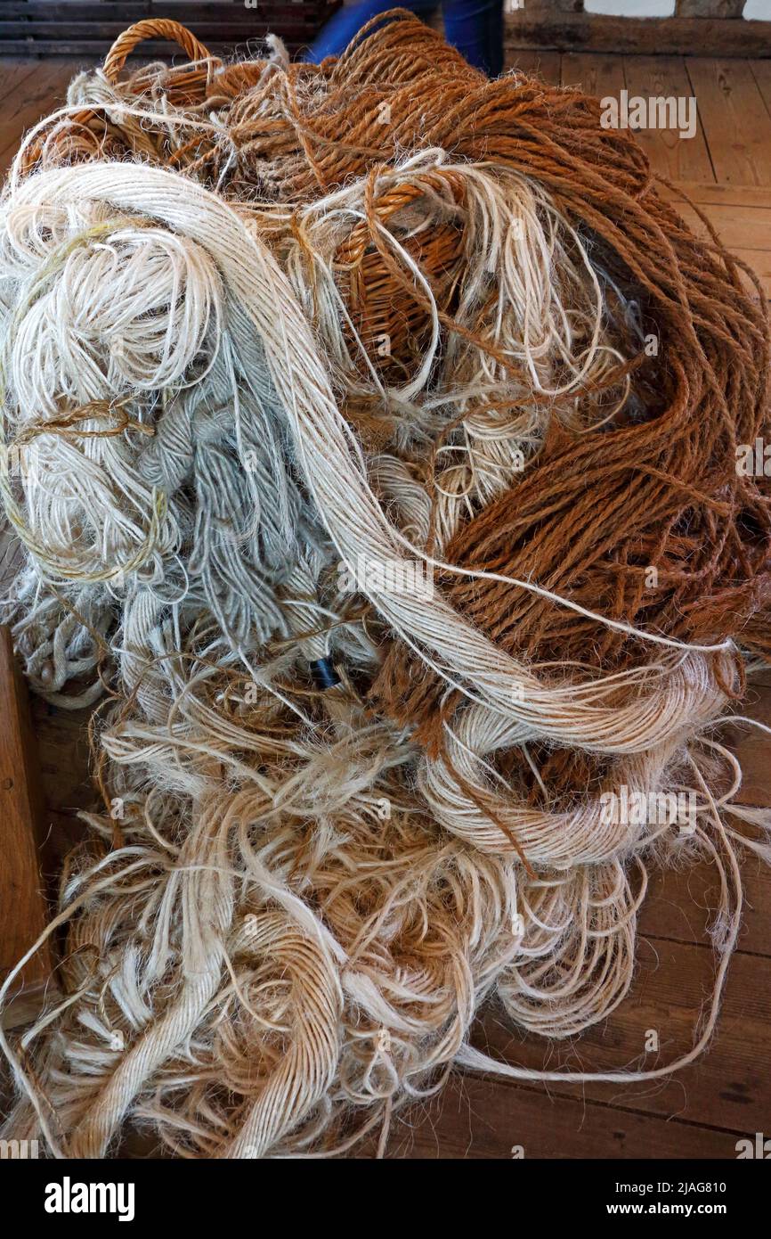 A wicker basket overflowing with various weaving yarns exhibited in the former medieval wool centre at Lavenham, Suffolk, England, United Kingdom. Stock Photo