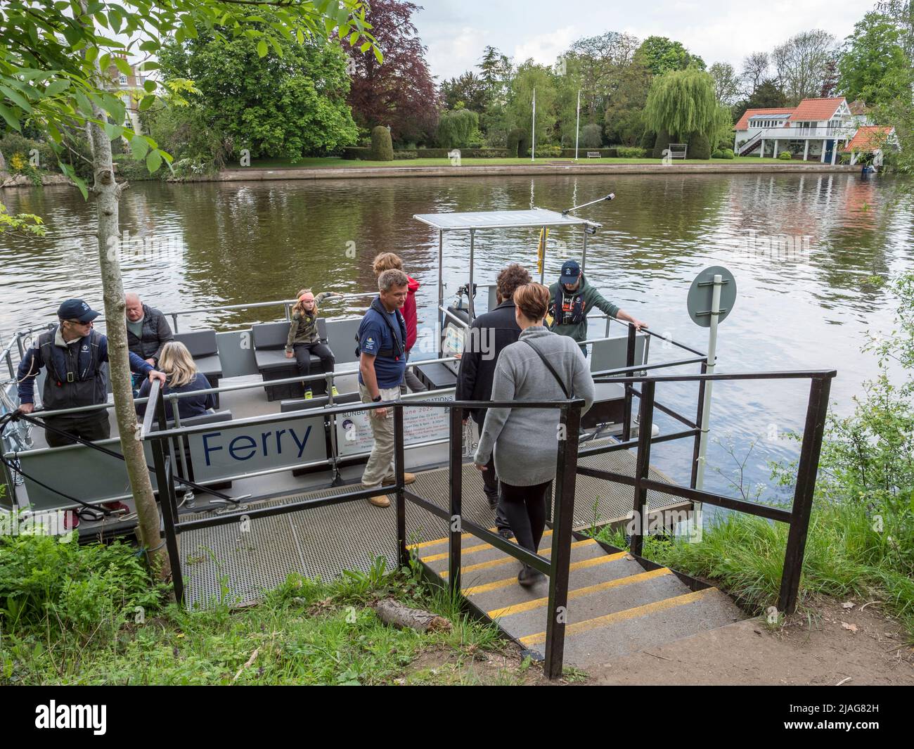 Passengers embarking on the Sunbury Ferry on the River Thames in Hampton, West London, UK. Stock Photo