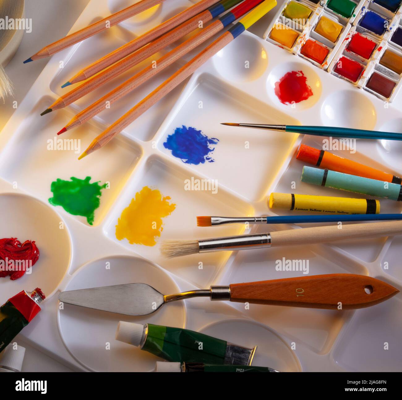 an illustration of art materials with brushes pencils and an artists palette with paints on a white background Stock Photo - Alamy