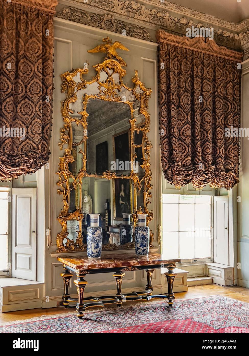 Ornate mirror at Petworth House in West Sussex, United Kingdom.  Petworth is a late 17th-century Grade I listed country house, rebuilt in 1688 by Char Stock Photo