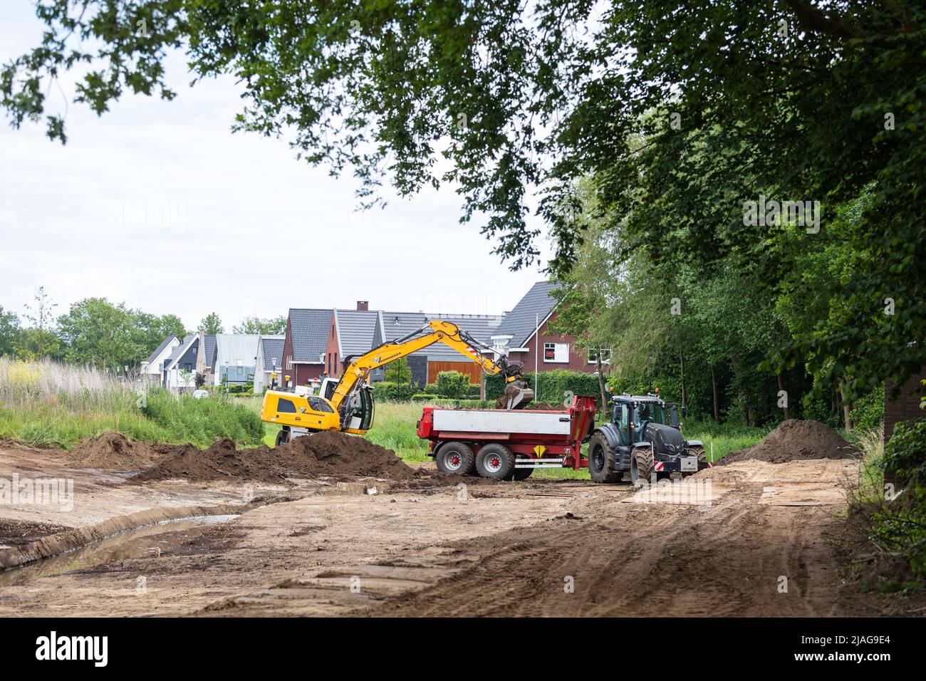 Excavators at work restoring canalized streamlet back to meandering shape in a residential area, water management in the Netherlands Stock Photo