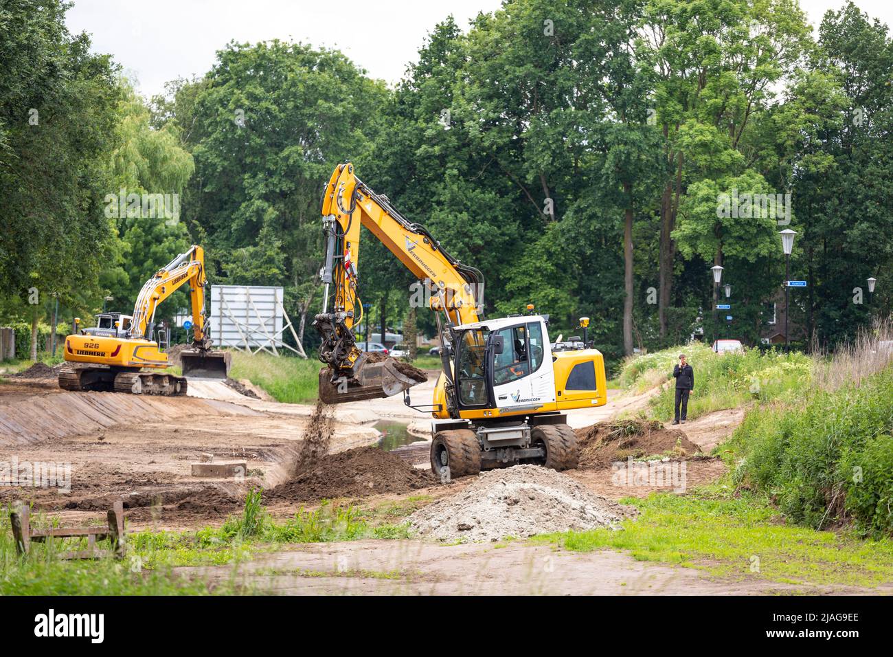 Excavators at work restoring canalized streamlet back to meandering shape in a residential area, water management in the Netherlands Stock Photo