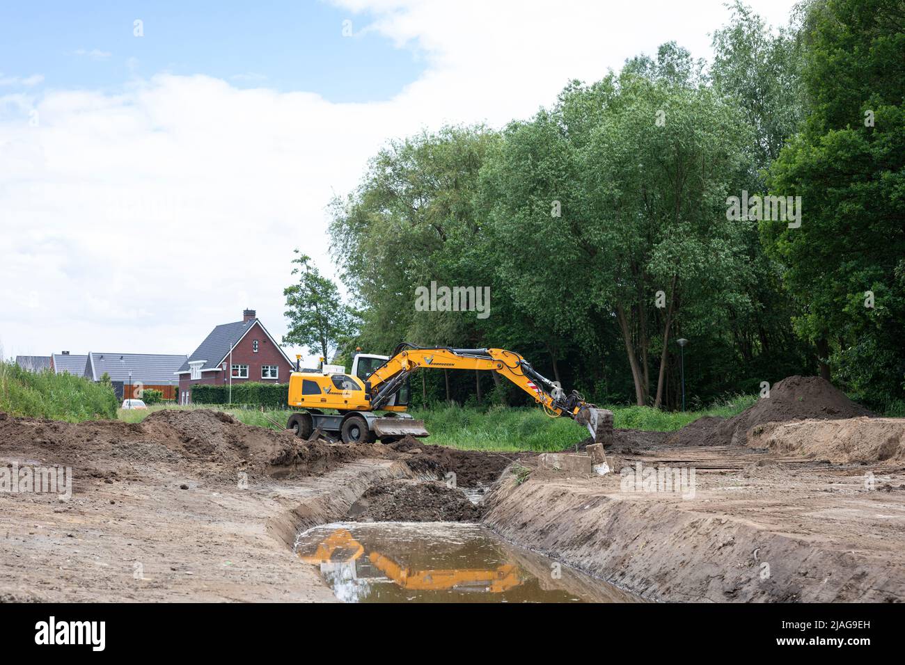 Excavators at work restoring canalized streamlet back to meandering shape in a residential area, water management in the Netherlands Stock Photo