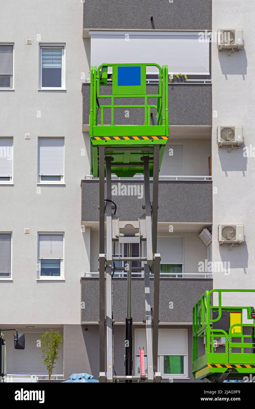Scissor Lift Aerial Work Platform at Building Exterior Stock Photo