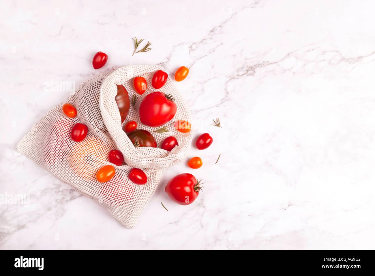 Cotton bag with tomatoes of different varieties and colors, tomato season Stock Photo