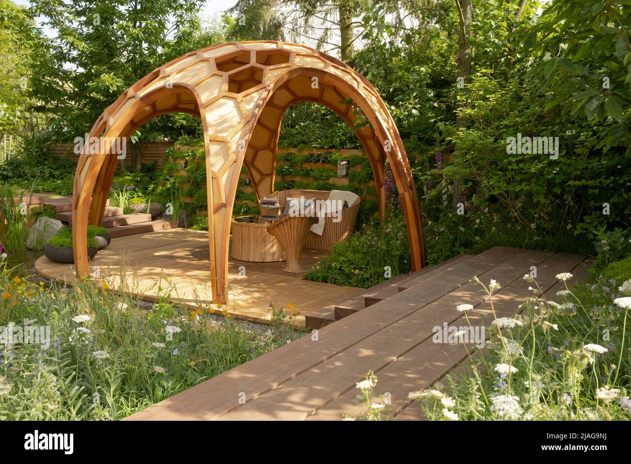 A dome shaped pavilion and sunken seating area in a woodland setting in The Meta Garden: Growing the Future designed by Joe Perkins Stock Photo