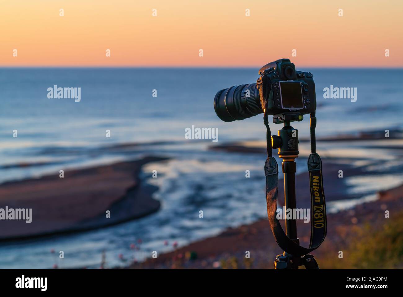 Nikon camera on a tripod by the sea Stock Photo