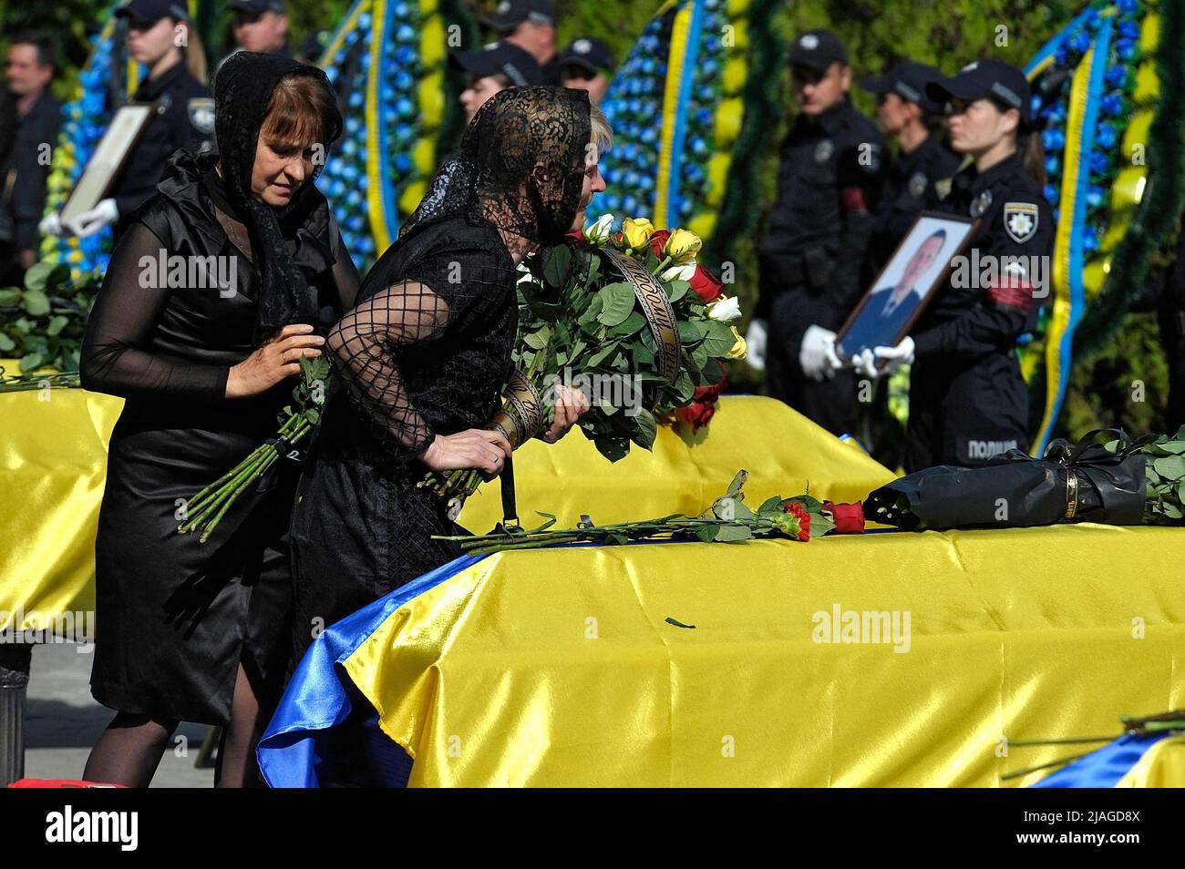 Non Exclusive: VINNYTSIA, UKRAINE - MAY 29, 2022 - Women lay flowers on the coffin with the body of one of the nine KORD servicemen who perished in a Stock Photo