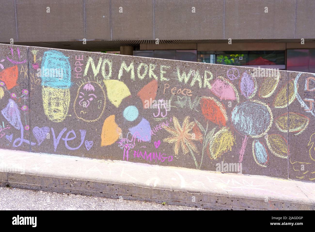 Chalk paintings made by people in the exterior areas of the New City Hall. There is a text reading 'No More War'. The inclusive initiative  is part of Stock Photo